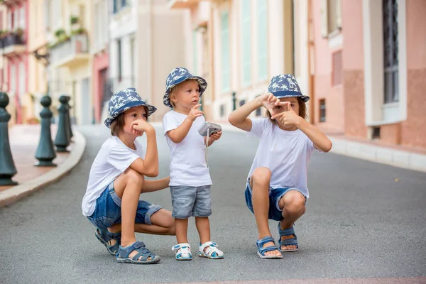 Kinder fotografieren in einer engen Straße mit Häusern in Monac — Stockfoto