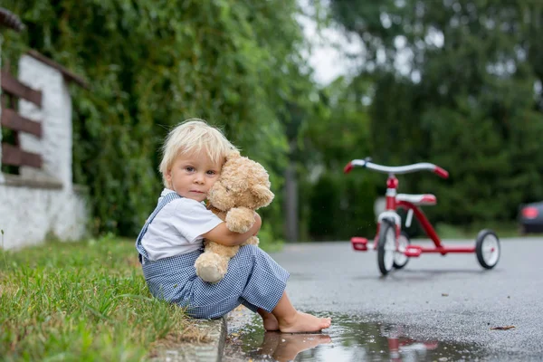 Cute Little Boy, z pluszowego niedźwiedzia Zabawka, siedząc na ulicy w t — Zdjęcie stockowe