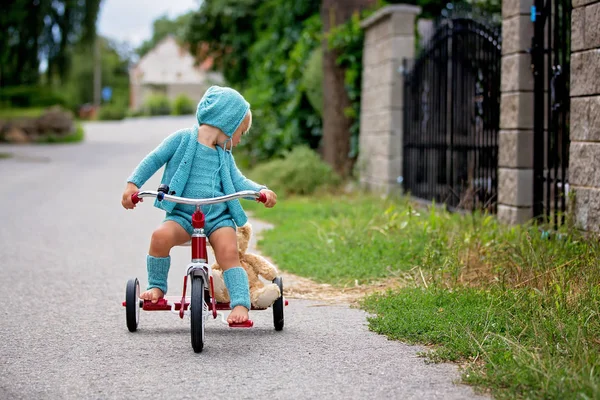 Очаровательный мальчик в трикотажном костюме, катается на трехколесном велосипеде на Q — стоковое фото