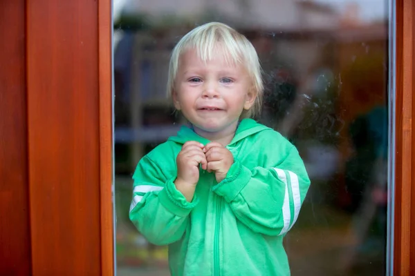 Toddle çocuk, ağır ağlıyor, kapının önünde duruyor — Stok fotoğraf