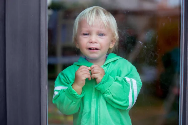 Toddle çocuk, ağır ağlıyor, kapının önünde duruyor — Stok fotoğraf