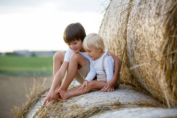 Happy children, playing on haystacks summertime — Stock Photo, Image