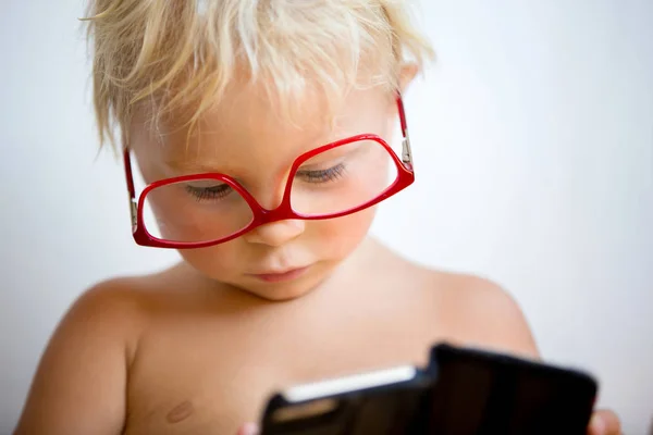 甜蜜的幼儿男孩与红色眼镜在白色背景，马金 — 图库照片