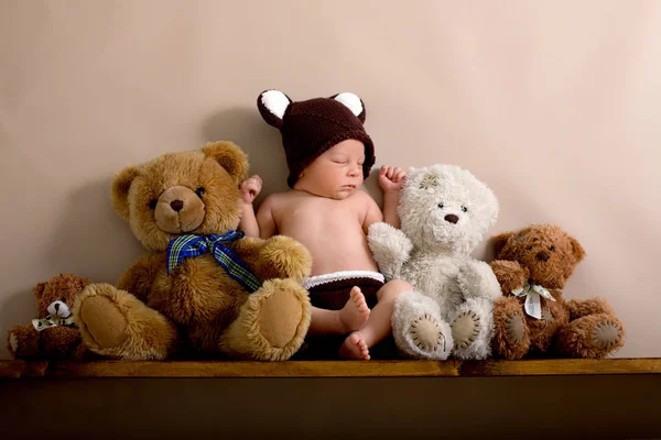 Newborn baby boy wearing a brown knitted bear hat and pants, sle — Stock Photo, Image