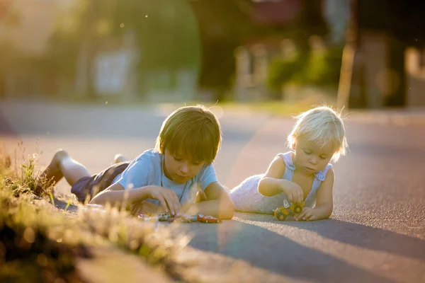 Crianças bonitas, meninos irmãos, brincando com brinquedos de carro no sunse — Fotografia de Stock