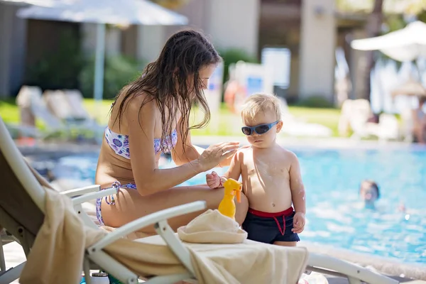 Mutter cremt Gesicht und Schultern ihrer Söhne mit Sonnencreme ein — Stockfoto