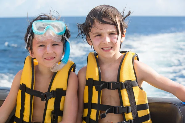 Familia feliz con chalecos salvavidas, divertirse en un viaje en barco mientras está en — Foto de Stock