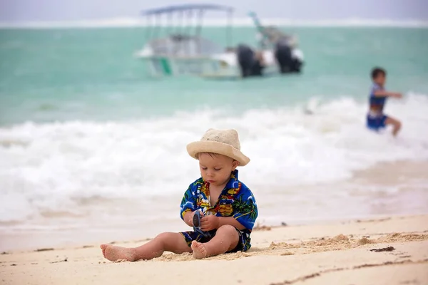 Lindo bebé jugando con juguetes de playa en la playa tropical — Foto de Stock