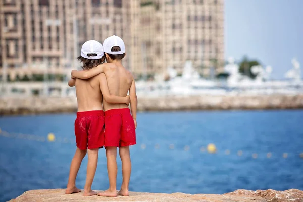 海滩上的两个男孩在岩石码头玩得很开心 — 图库照片
