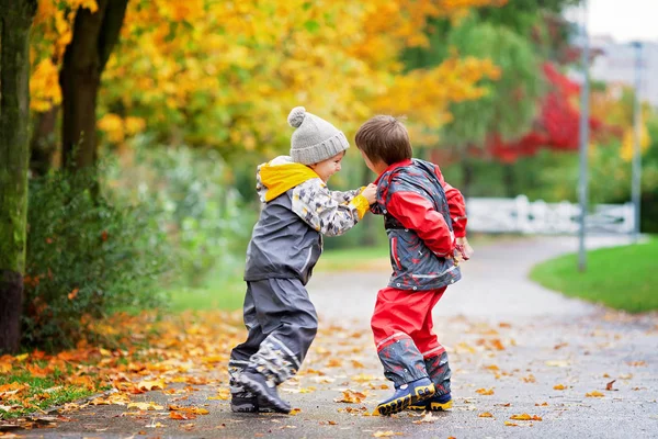 Two children, fighting over toy in the park on a rainy day — Stock Photo, Image