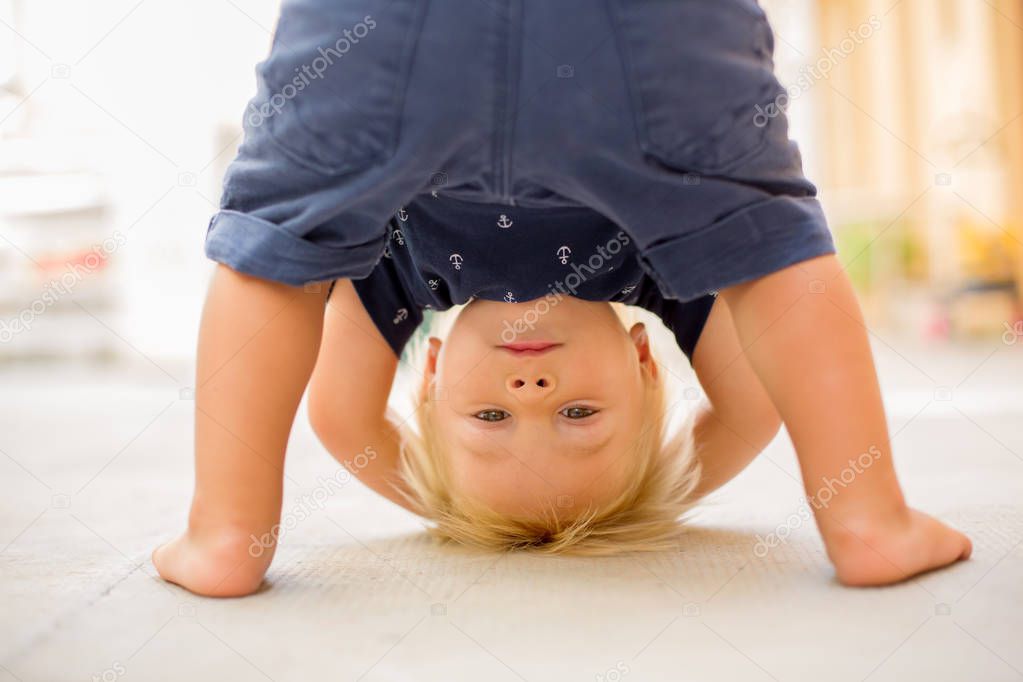 Child standing upside down, smiling happily