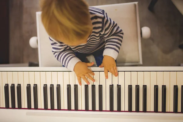 Dulce niño positivo jugando al piano. Educación musical temprana —  Fotos de Stock