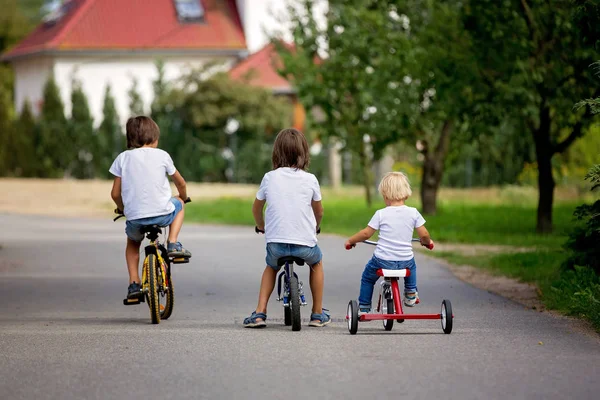 Drei Kinder, auf dem Fahrrad, Dreirad und Laufrad unterwegs — Stockfoto