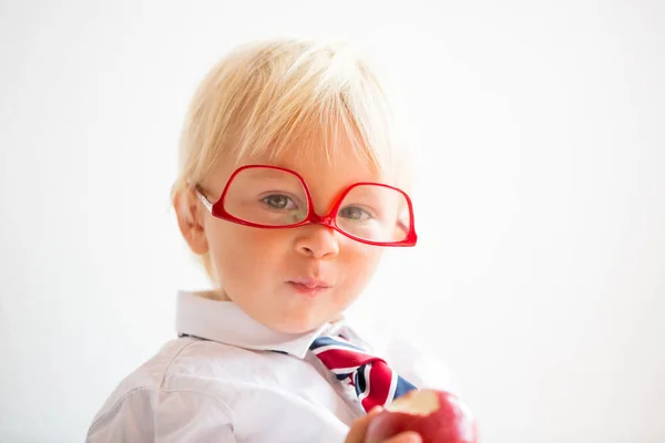 Niedliches Kind, mit Brille und Apfel essen, gekleidet für die erste da — Stockfoto