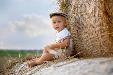 Mutlu çocuklar, yaz aylarında samanlıkta oynuyorlar.