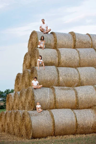 Happy family, sitting on a haystack, every member of the family — Stock Photo, Image
