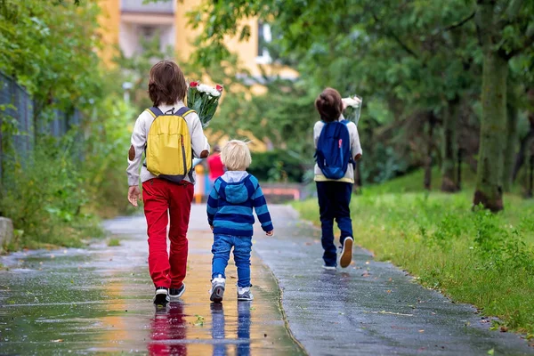 Bambini felici della scuola, tenendo mazzo di fiori, andando a scho — Foto Stock