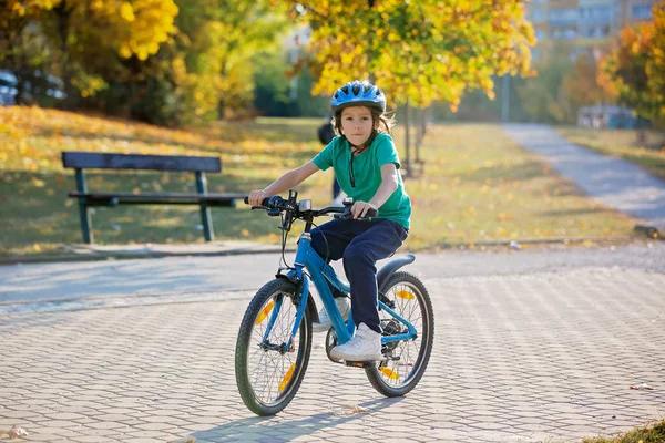 Fröhlicher Junge, der sich im Herbstpark mit dem Fahrrad vergnügt — Stockfoto