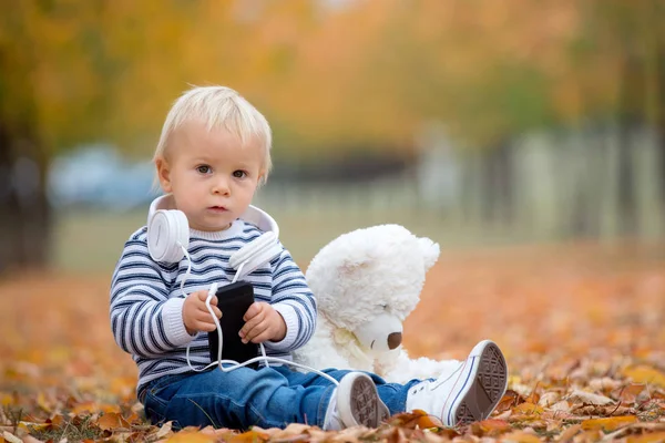 Petit garçon tout-petit, jouer avec l'ours en peluche à l'automne p — Photo