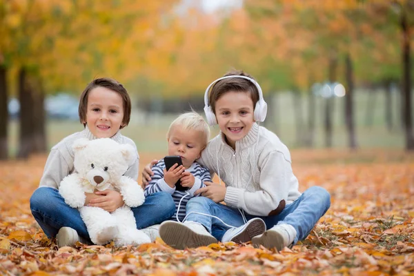 Ritratto di adorabili bambini, fratelli, nel parco autunnale, listeni — Foto Stock