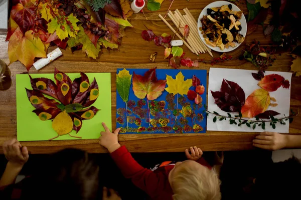 Children, applying leaves using glue, scissors, and paint, while — Stock Photo, Image