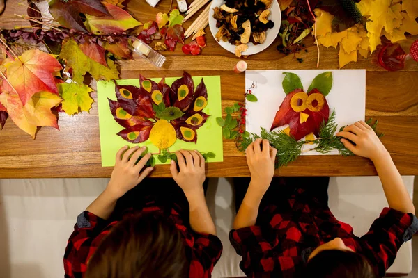 Діти, наносити листя за допомогою клею, ножиць і фарби, в той час як — стокове фото