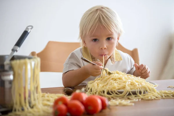 Little baby boy, toddler child, eating spaghetti for lunch and m Stock Image