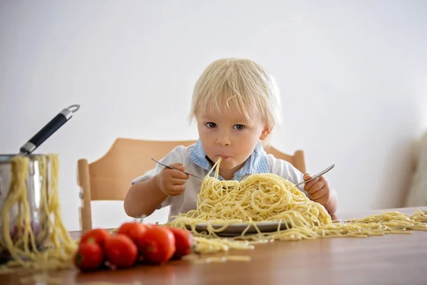 Маленький мальчик, маленький ребенок, ест спагетти на обед и м — стоковое фото