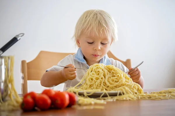 Little baby boy, toddler child, eating spaghetti for lunch and m Stock Photo