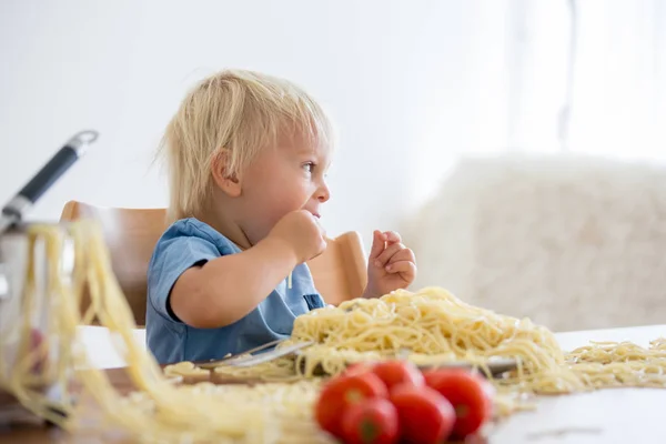 Little baby boy, toddler child, eating spaghetti for lunch and m Royalty Free Stock Photos