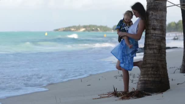 妈妈和蹒跚学步的男孩 愉快地拥抱在海边 放松和享受海浪 — 图库视频影像