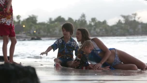 幸せな美しいファッションの家族 子供たち ハワイのシャツを着て 日没のビーチで一緒に遊んで 家族の喜びの休暇 — ストック動画