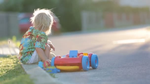 Ребенок Играющий Пластиковыми Игрушками Блоками Машинами Закате Маленькой Деревне — стоковое видео