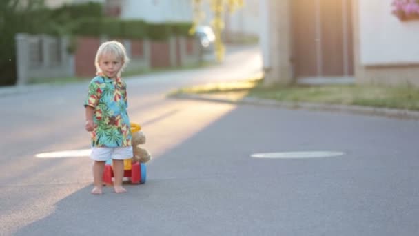 美丽的幼儿 在一个小村子里玩塑料玩具 日落时的汽车 — 图库视频影像