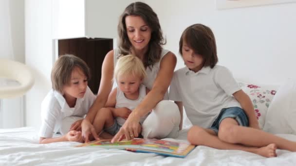 Joven Madre Lee Libro Sus Tres Hijos Niños Dormitorio Soleado — Vídeos de Stock