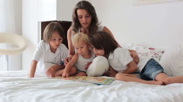 Joven Madre Lee Libro Sus Tres Hijos Niños Dormitorio Soleado — Vídeo de stock