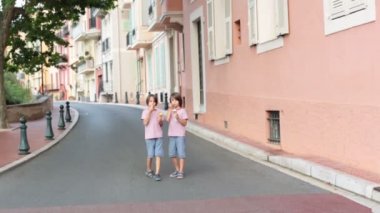 Çocuklar bulutlu bir günde Monako-Ville, Monako evleri ile dar bir sokakta yürüyüş. Monako-Ville, Monako'nun dört geleneksel çeyreğinden biridir.