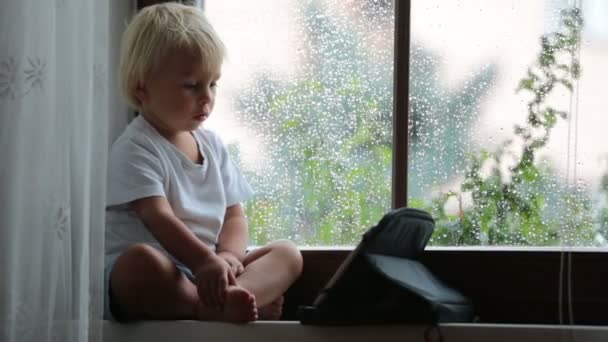 Rozkošný Chlapeček Který Sedí Štítu Hraje Tabletu Deštivého Dne — Stock video