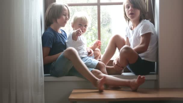 Irmãos Felizes Irmãos Meninos Sentados Escudo Janela Dia Chuvoso Brincando — Vídeo de Stock