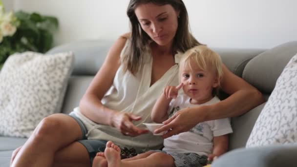 Encantadora Madre Mostrando Imágenes Libro Lindo Bebé Casa Comiendo Cerezas — Vídeo de stock