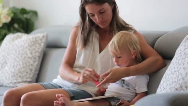 Encantadora Madre Mostrando Imágenes Libro Lindo Bebé Casa Comiendo Cerezas — Vídeo de stock