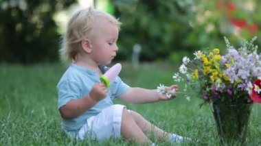 Cute blond toddler boy, eating homemade fruit ice cream