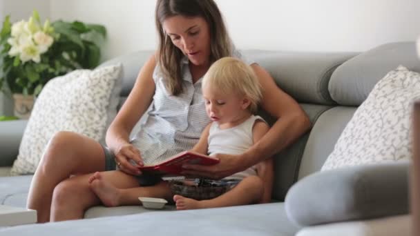 Encantadora Madre Mostrando Imágenes Libro Lindo Bebé Casa Comiendo Cerezas — Vídeos de Stock