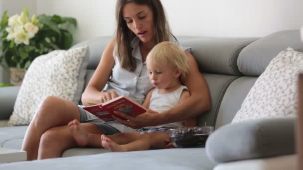 Encantadora Madre Mostrando Imágenes Libro Lindo Bebé Casa Comiendo Cerezas — Vídeo de stock