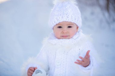 Bebek kışın karda Teddy ile oynuyor. Küçük çocuk.