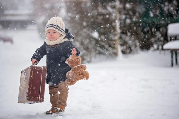 Bebé jugando con peluche en la nieve, en invierno. Pequeño niño. —  Fotos de Stock