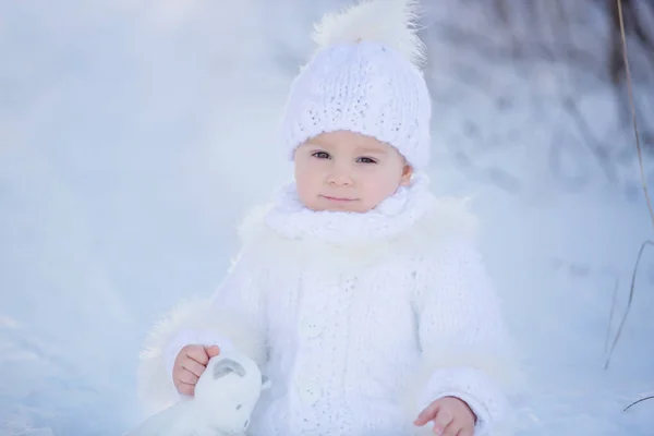Baby spelen met teddy in de sneeuw, winter tijd. Kleine peuter — Stockfoto