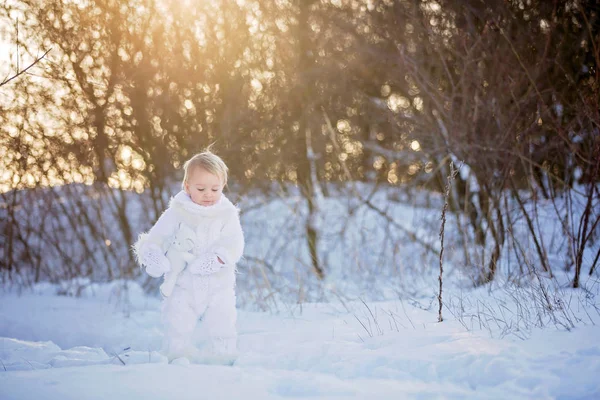 Baby spielt mit Teddy im Schnee, Winterzeit. kleines Kleinkind — Stockfoto