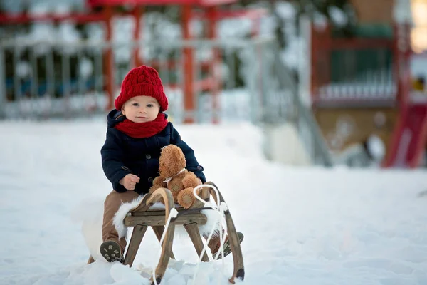 Baby spielt mit Teddy im Schnee, Winterzeit. kleines Kleinkind — Stockfoto
