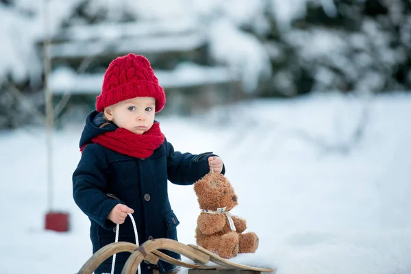 Baby spelen met teddy in de sneeuw, winter tijd. Kleine peuter — Stockfoto